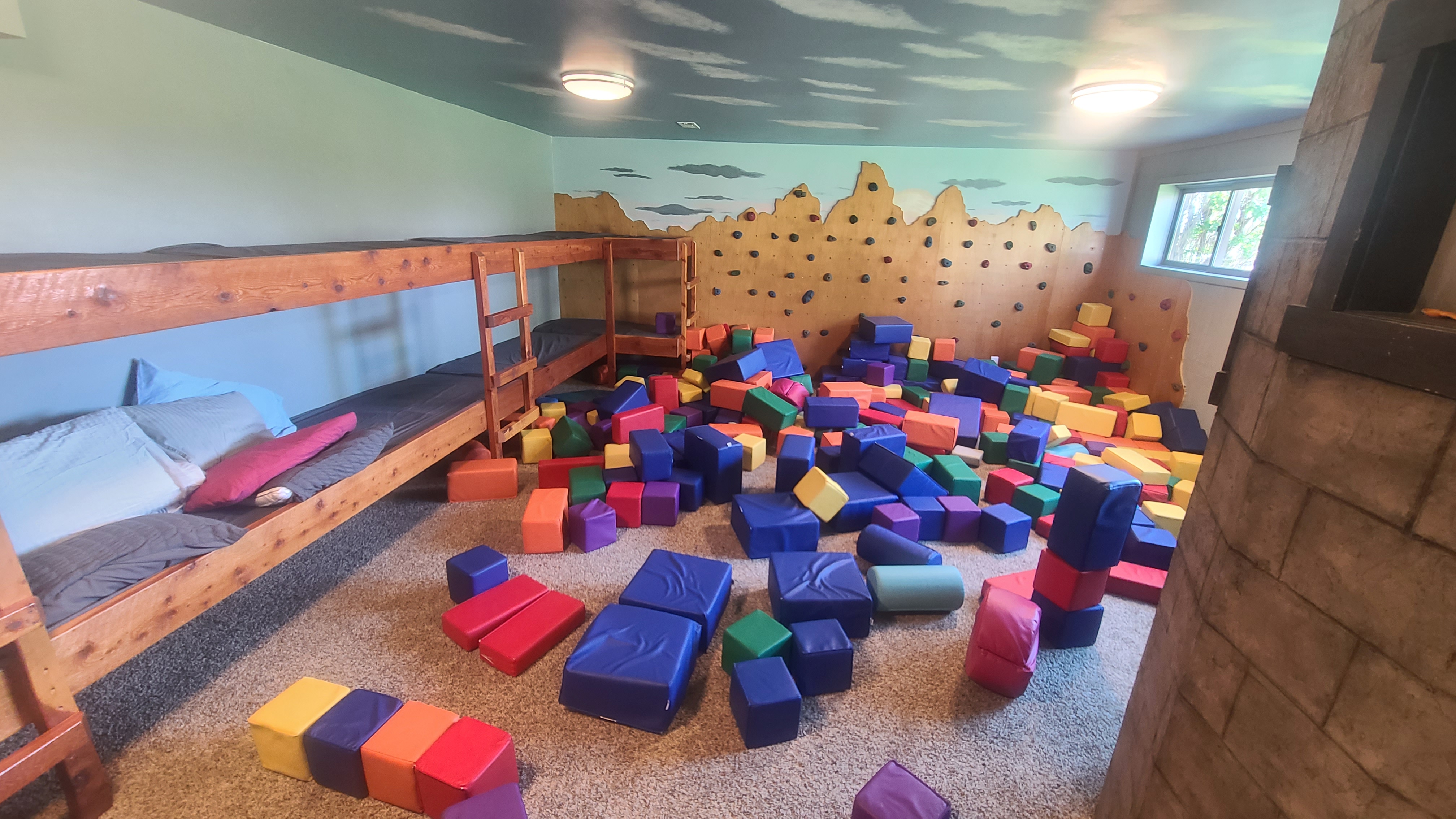 Indoor bunk room and playroom with climbing wall