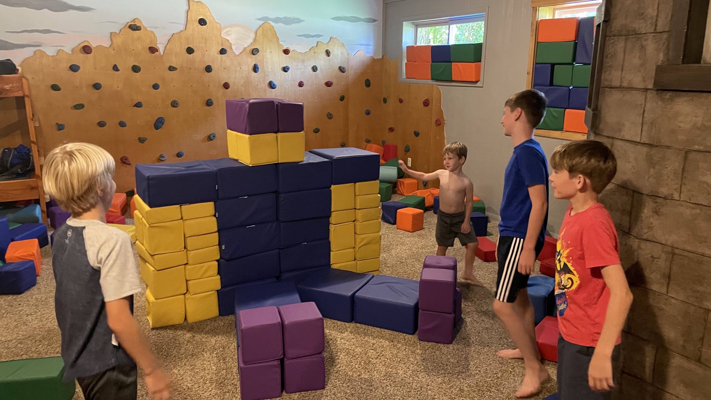 Kids building with foam blocks under the mountain climbing wall