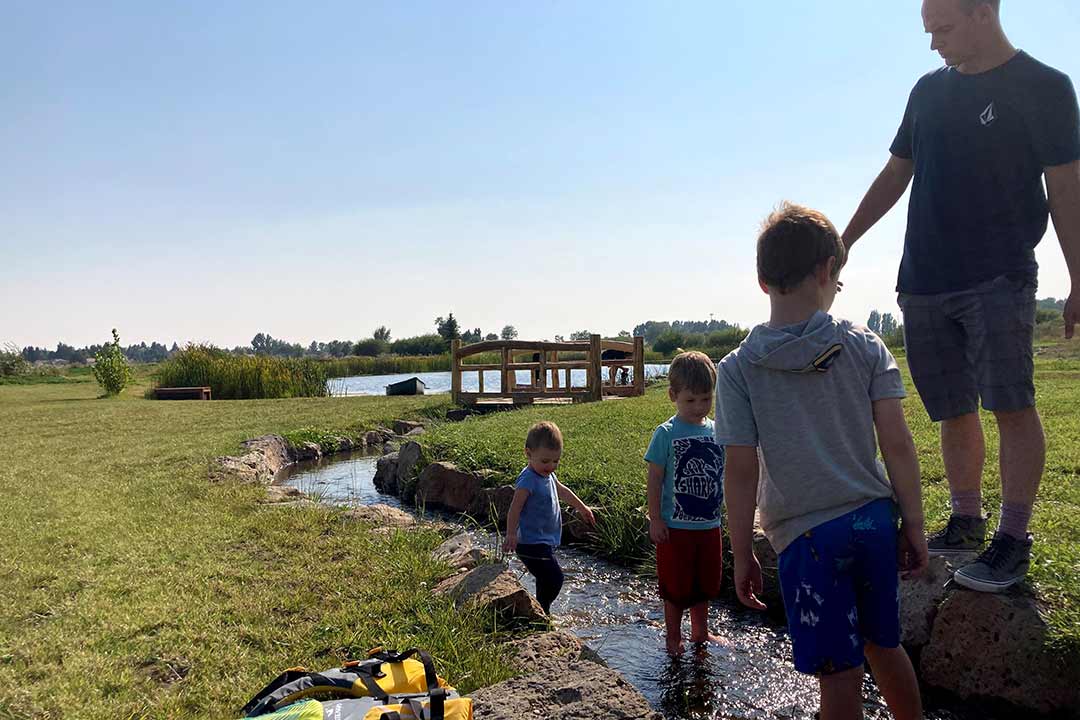 Family with children playing by the stream on the property