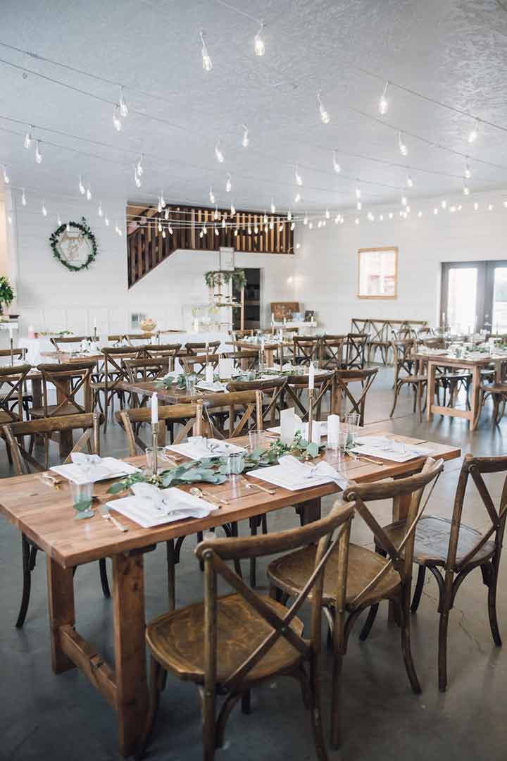 Indoor reception with farm tables and string lights